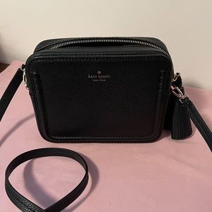 Kate Spade Crossbody Has a front pocket is very roomy.Goes well with any outfit.